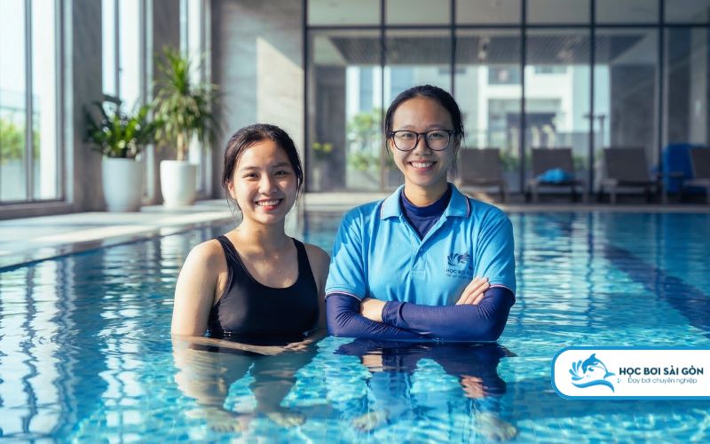 Học viên nữ cười rạng rỡ đầy tự tin sau khi hoàn thành khóa học bơi cho nữ tại hồ bơi chung cư cao cấp.