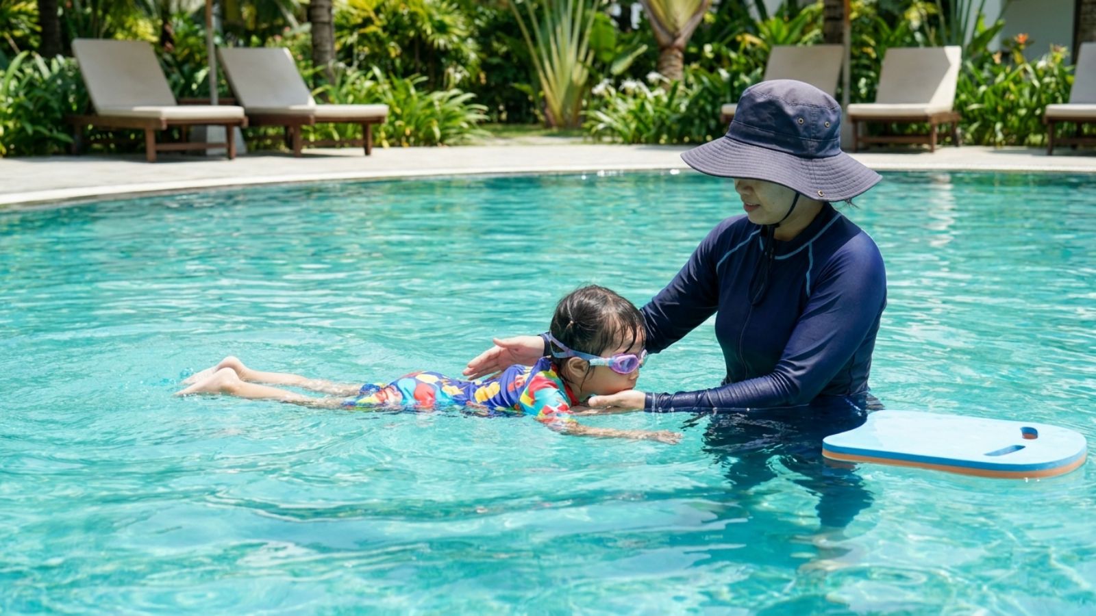 Em bé học bơi với HLV tại hồ bơi ngoài trời